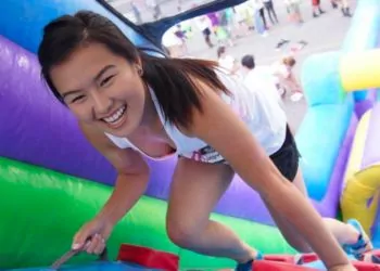 Teen girl climbing inflatable obstacle course at a Winter Haven event